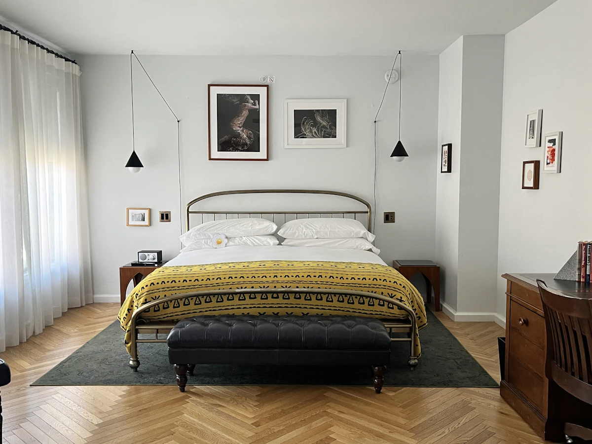 Dormitorio con cama de metal y obra de arte